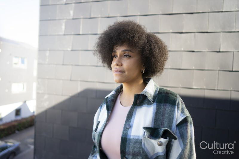 Woman in plaid shirt standing outdoors