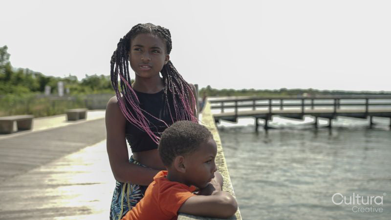 Brother and sister standing on pier