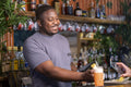 Smiling bartender with credit car reader and tablet at bar, USUN wiek kobiety