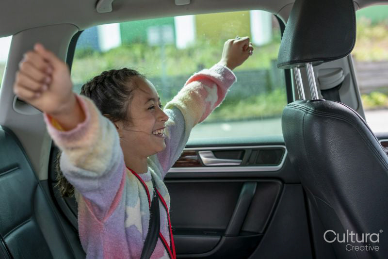 Smiling girl sitting in back of car