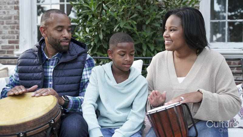 Family with son playing drums on patio