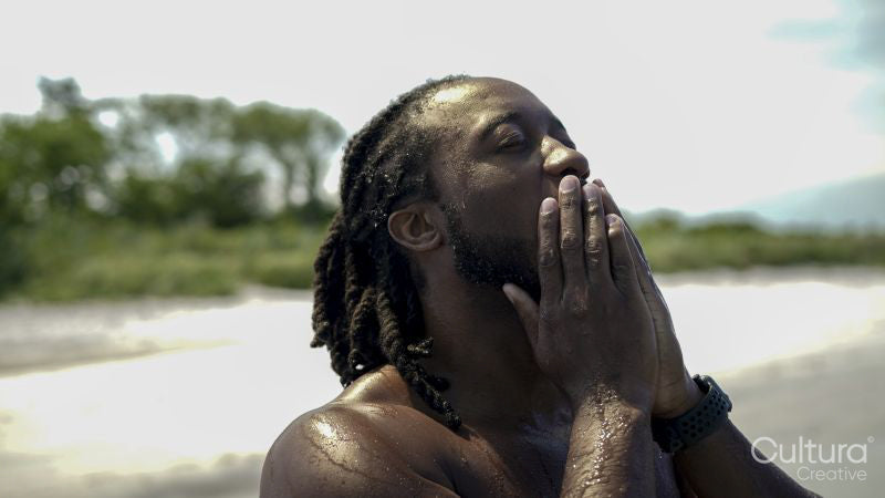 Close-up of man on beach touching face