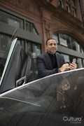 Mature man standing by luxury car and using phone