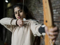 Brunette young woman concentrating during archery training