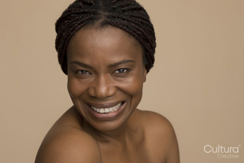 Studio portrait of smiling mature woman with braided hair