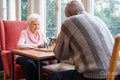 Senior people playing chess in nursing home