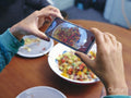 Woman taking picture of lunch with smart phone