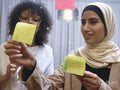Women using adhesive notes in office