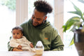 Smiling father holding baby daughter at home