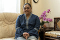 Portrait of young woman with down syndrome sitting on sofa at home