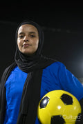 Portrait of female soccer player holding ball