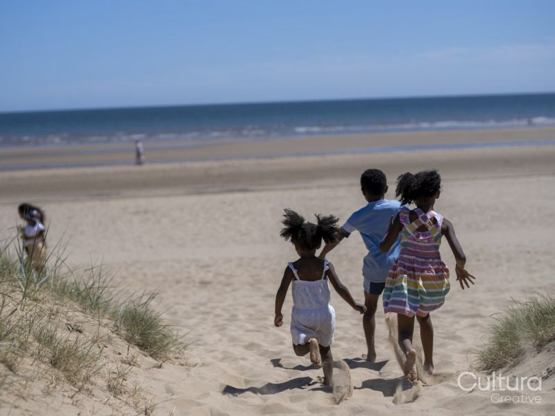 Siblings running on beach