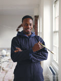 Portrait of smiling man holding paintbrush during renovation