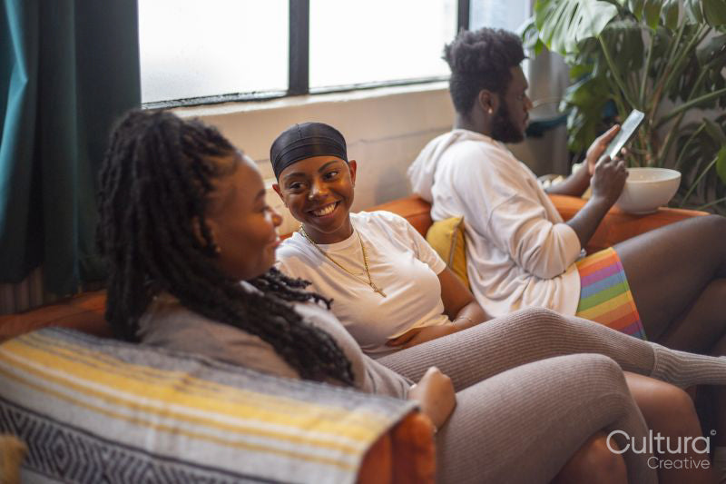Friends relaxing on sofa at home