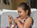 Girl looking at smart phone on sofa