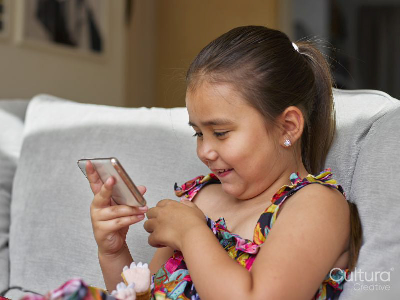 Girl looking at smart phone on sofa