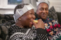 Senior couple sitting on sofa eating Christmas cookies