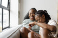 couple laughing while sitting on sofa at home