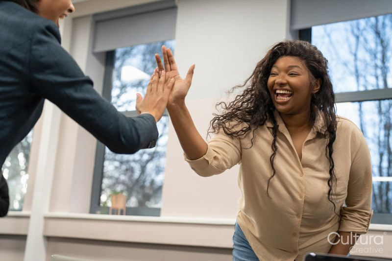 Businesswomen high fiving in office