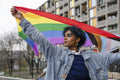 Young woman holding progress pride flag