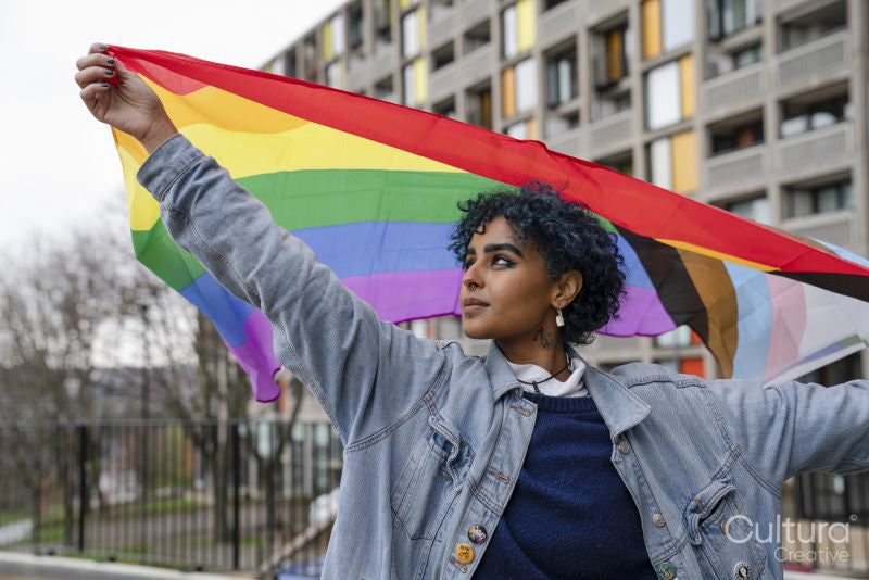 Young woman holding progress pride flag