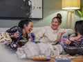 Friends laughing on sofa in living room