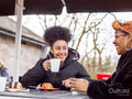 Mother with daughter sitting at outdoor cafe table