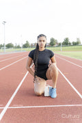 Female athlete preparing to run at stadium