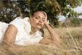Portrait of young woman lying in grassy field