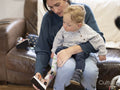 Mother putting leg brace on small son
