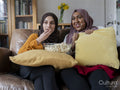 Friends eating popcorn and watching TV at home