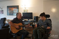 Father playing guitar with disabled son