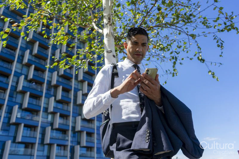 Businessman using phone outdoors