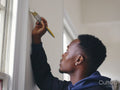 Man painting house walls white