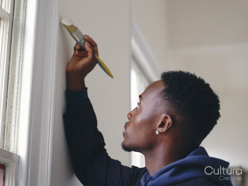 Man painting house walls white