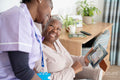 Smiling caregiver and senior woman looking at photography