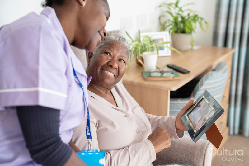 Smiling caregiver and senior woman looking at photography