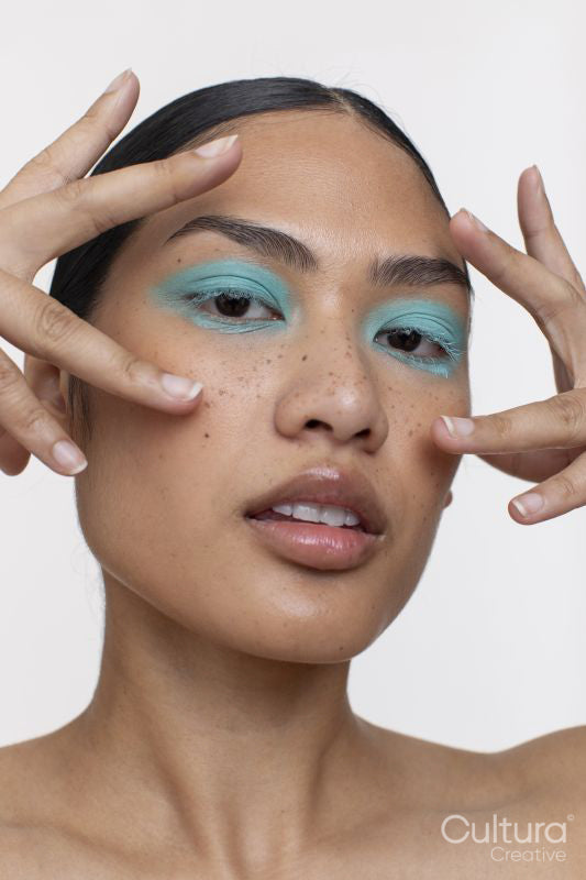 Portrait of woman with black hair and blue makeup