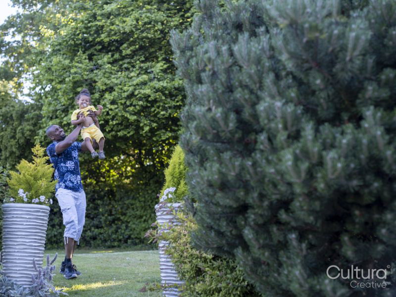 Father lifting son in air in garden