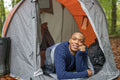 Man lying in tent and looking at trees
