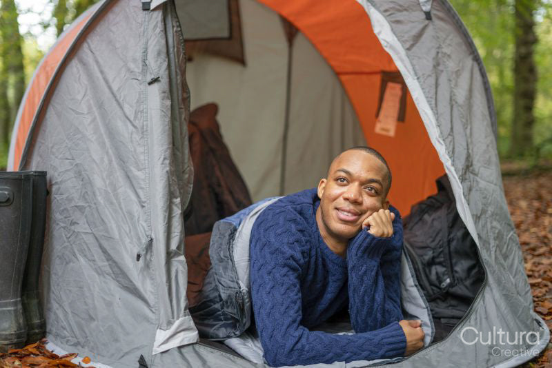 Man lying in tent and looking at trees