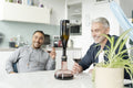 Male couple using wine breather decanter at home