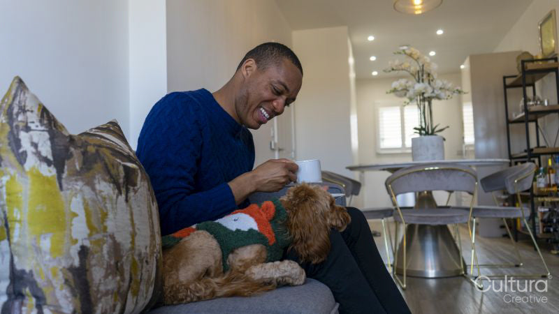 Man with dog sitting on sofa