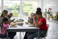 Family praying before eating dinner