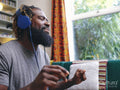 Man sitting on sofa,listening to music on headphones