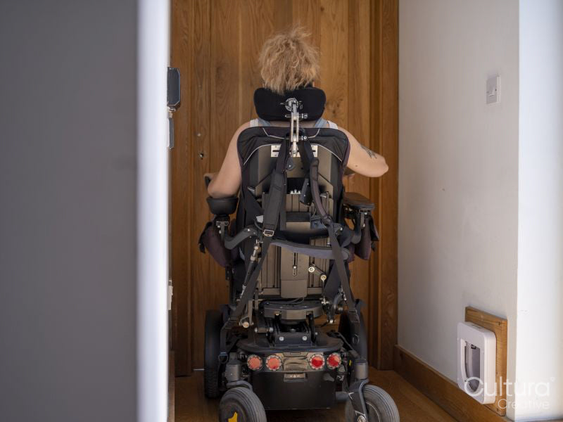 Woman in electric wheelchair going through automatic doors