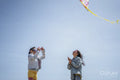 Mother and daughter flying kite on beach