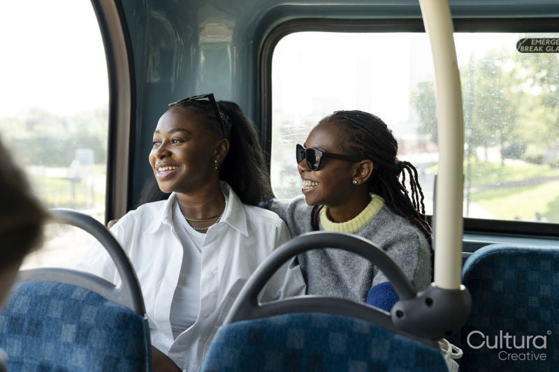 Young female friends riding city bus