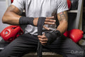 Mature man wrapping hands for boxing match, midsection