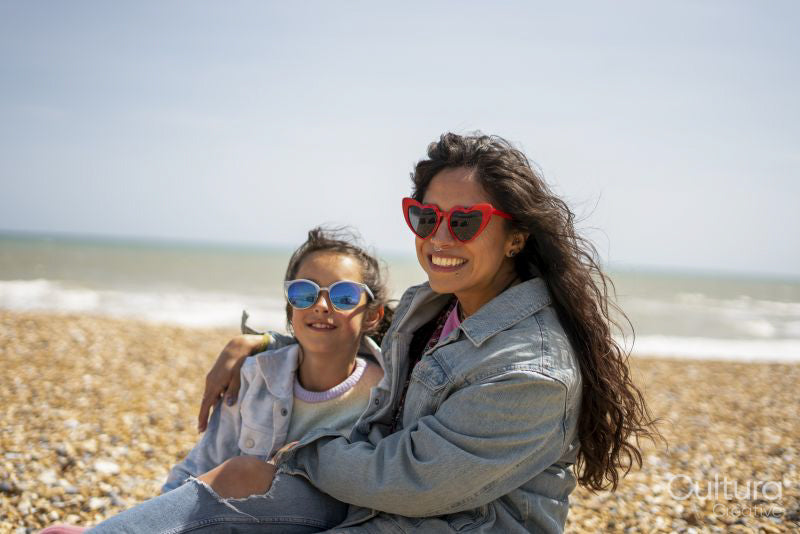 Smiling mother and daughter on beach